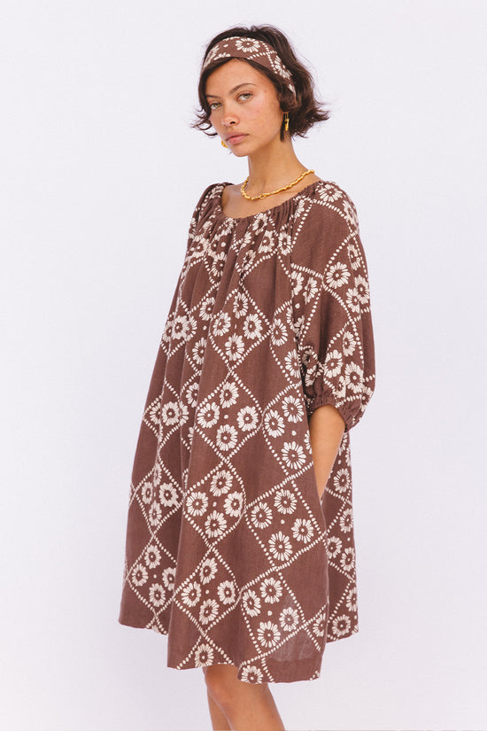 Dahlia Mini Dress Maple — studio model with headband, diagonal pose showing side pocket, hand block print linen mini in maple brown diamond pattern, Jaipur artisan boho dress, ethical cotton | Daughters of India