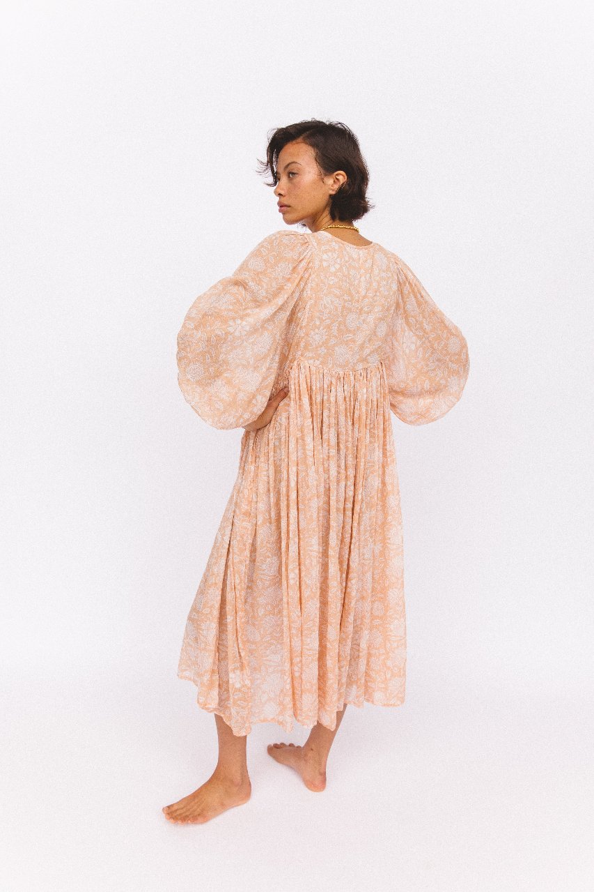 Daughters of India Kyra Midi Dress in Apricot Blush — studio back view walking, gathered waist and billowed sleeves
