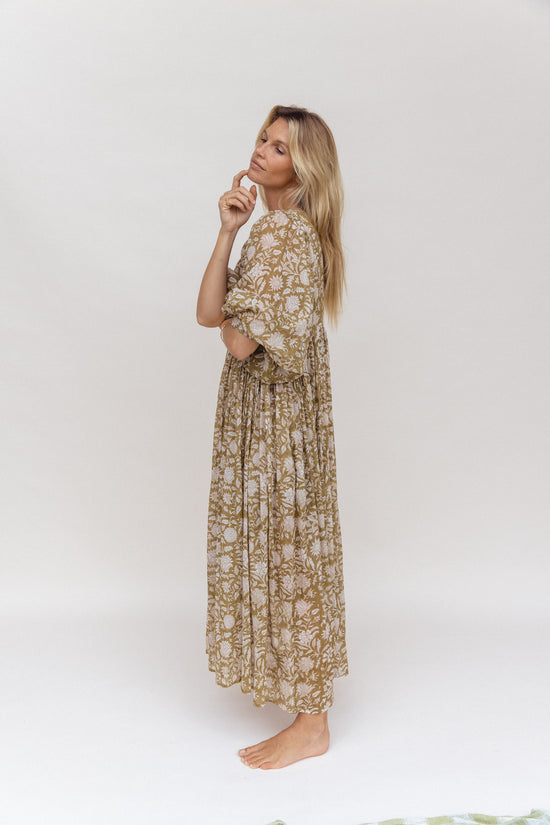 Daughters of India Kyra Maxi Dress in Olive — studio side profile, finger on chin, gathered waist detail