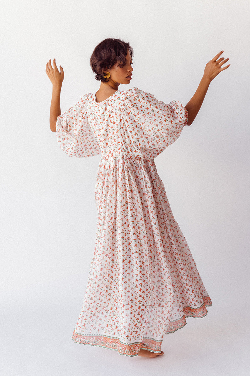 Daughters of India Kyra Maxi Dress in Coral — studio back view turning, flowing skirt and border hem detail