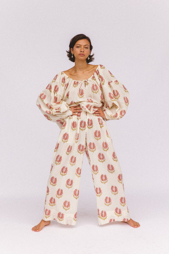 Ria Blouse Strawberry Cream — outdoor lifestyle portrait, model in natural setting, strawberry cream block print cotton blouse, Jaipur artisan made | Daughters of India